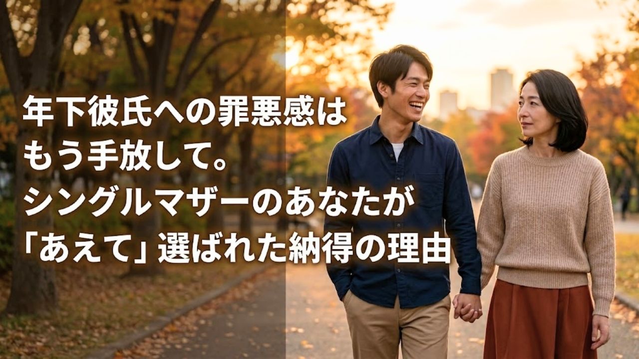 秋の公園で手を繋いで微笑み合う、シングルマザーと年下彼氏の年の差カップル。夕暮れの光の中で前向きな未来を象徴。画像左側のテキストは「年下彼氏への罪悪感はもう手放して。シングルマザーのあなたが『あえて』選ばれた納得の理由」で、年の差恋愛の悩みを解決する記事のアイキャッチ画像。